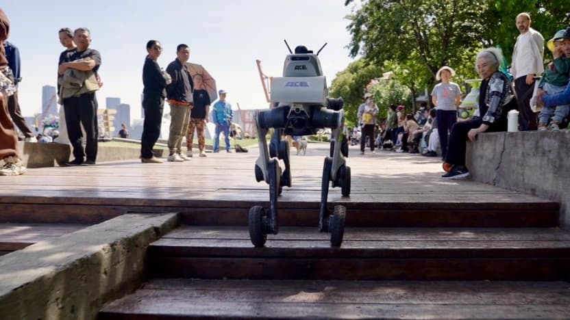 A patrol robot dog climbing steps in a mixed pedestrian area, handling unstructured terrain without a pre-built map.