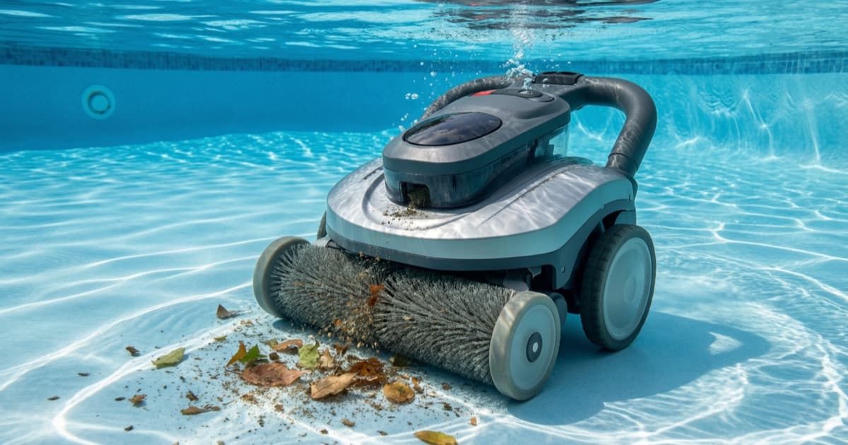 A cordless robotic pool cleaner vacuuming leaves and debris off a pool floor