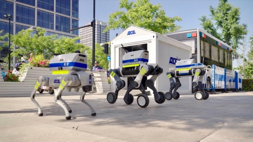 Three autonomous patrol robot dogs working alongside a mobile charging station in a public plaza.